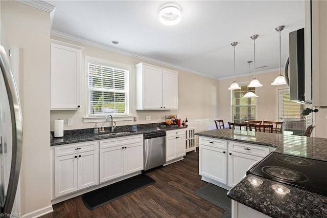 1951 Rubywood St, Greensboro, NC 27405 - kitchen with appliances with stainless steel finishes, dark wood-style floors, white cabinetry, crown molding, and hanging light fixtures