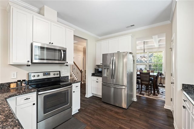 1951 Rubywood St, Greensboro, NC 27405 - kitchen with appliances with stainless steel finishes, dark wood finished floors, a chandelier, white cabinetry, and ornamental molding