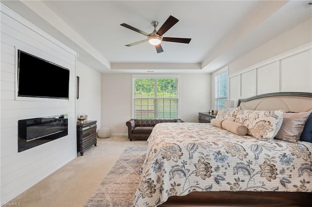 1951 Rubywood St, Greensboro, NC 27405 - bedroom with light carpet, a tray ceiling, multiple windows, and ceiling fan