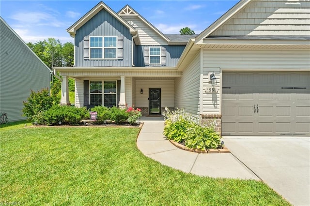 1951 Rubywood St, Greensboro, NC 27405 - view of front of property featuring board and batten siding, a front lawn, concrete driveway, a garage, and stone siding