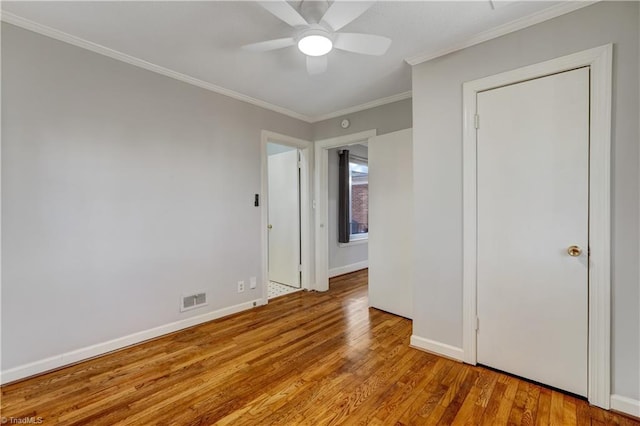 unfurnished bedroom with light hardwood / wood-style flooring, ceiling fan, and ornamental molding