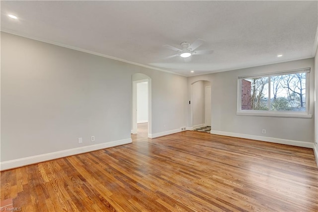 empty room with ceiling fan, ornamental molding, and light hardwood / wood-style floors