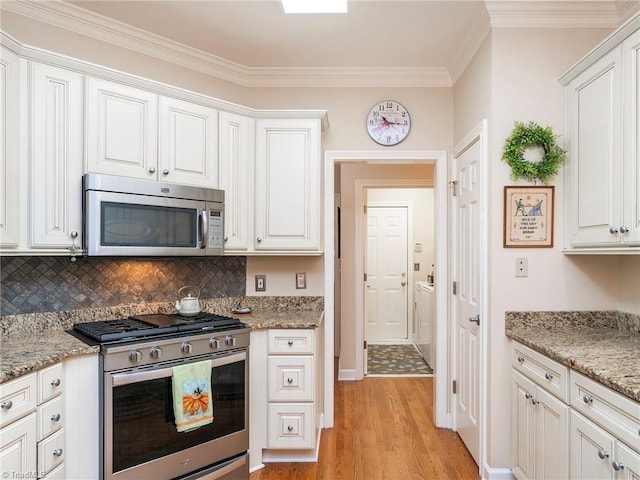 kitchen with stainless steel appliances, light stone countertops, and white cabinets