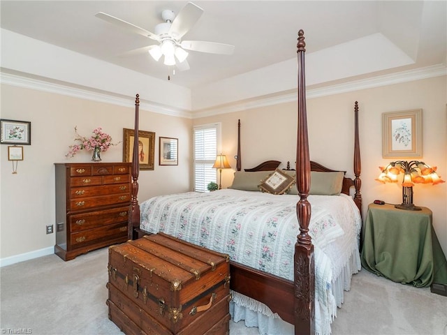 carpeted bedroom with ornamental molding, a raised ceiling, and ceiling fan