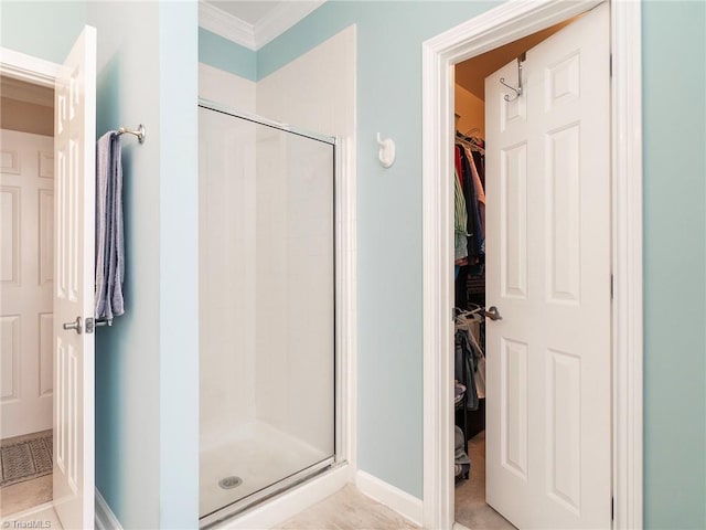 bathroom with crown molding and an enclosed shower