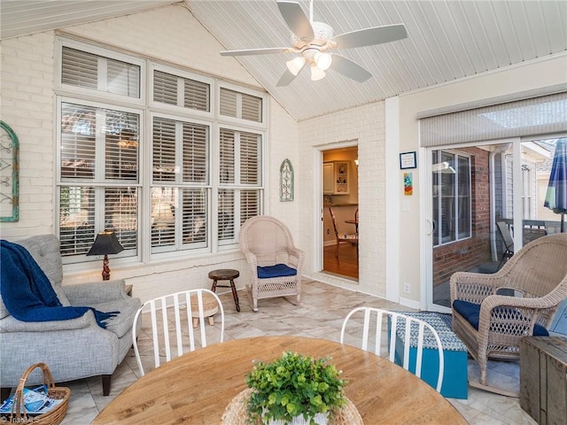 sunroom / solarium featuring ceiling fan and vaulted ceiling