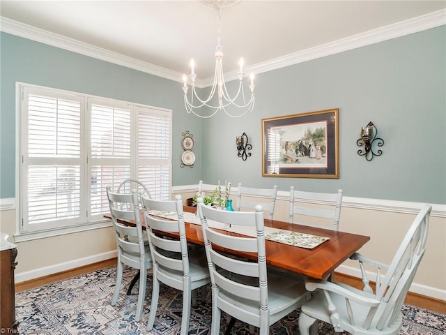 dining space featuring ornamental molding, wood-type flooring, and a chandelier