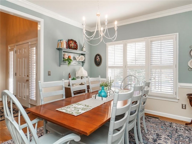 dining area with hardwood / wood-style flooring, crown molding, and an inviting chandelier