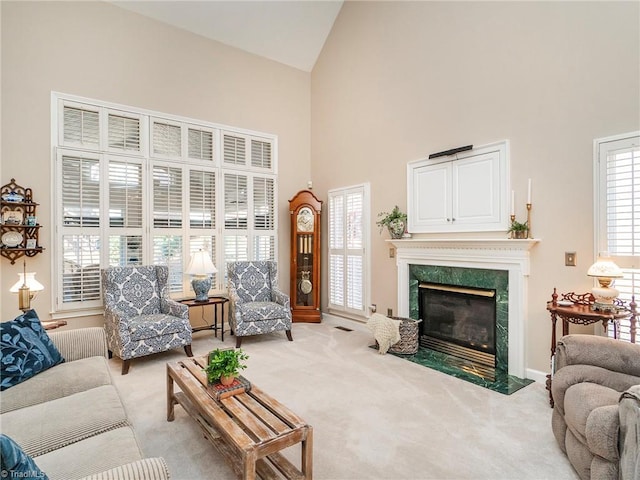 living room featuring light carpet, high vaulted ceiling, and a premium fireplace