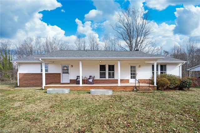 rear view of property with a porch, a lawn, and brick siding