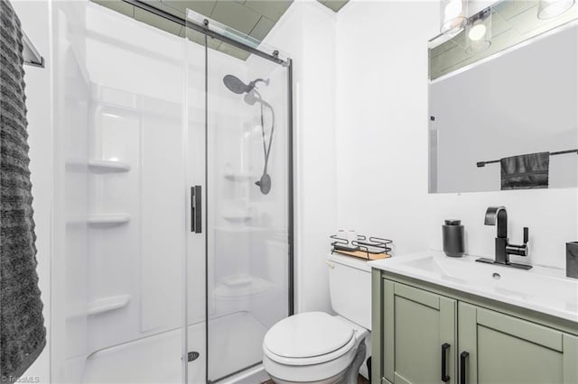 bathroom with toilet, a stall shower, and vanity