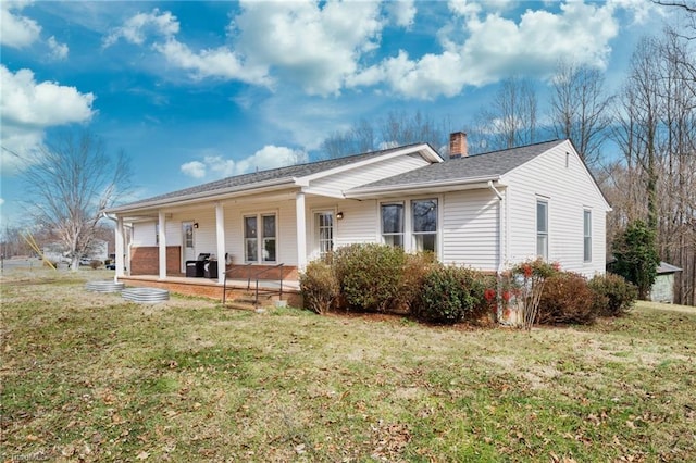 view of front of home featuring a porch, a chimney, and a front lawn