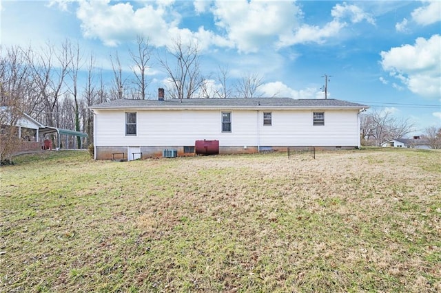 back of property with crawl space, central AC, and a lawn