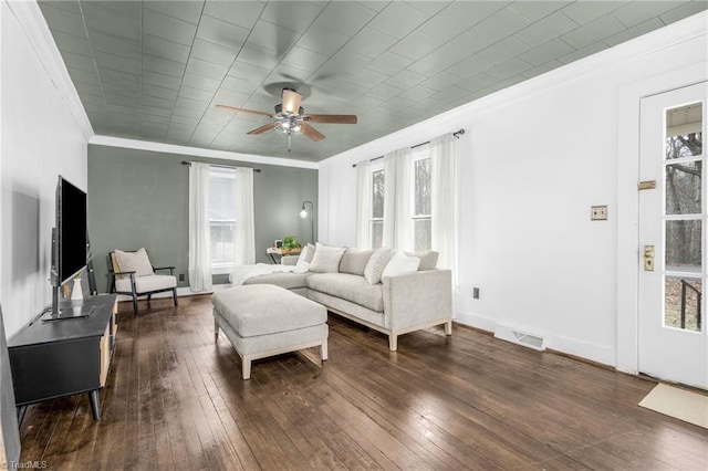 living area with dark wood-style floors, ornamental molding, visible vents, and a ceiling fan