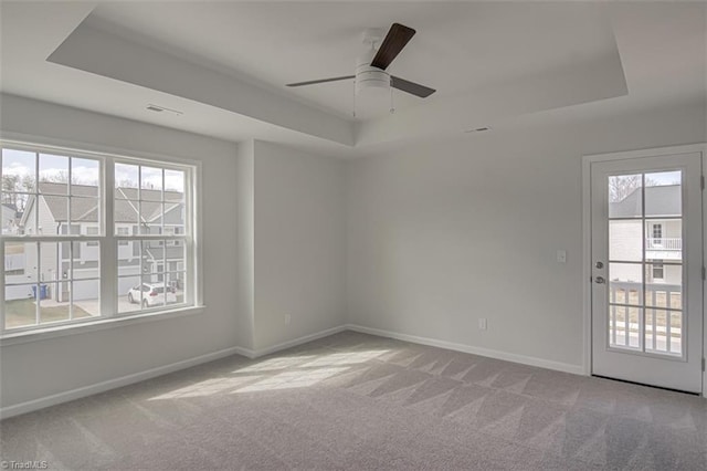 spare room featuring a tray ceiling and carpet flooring