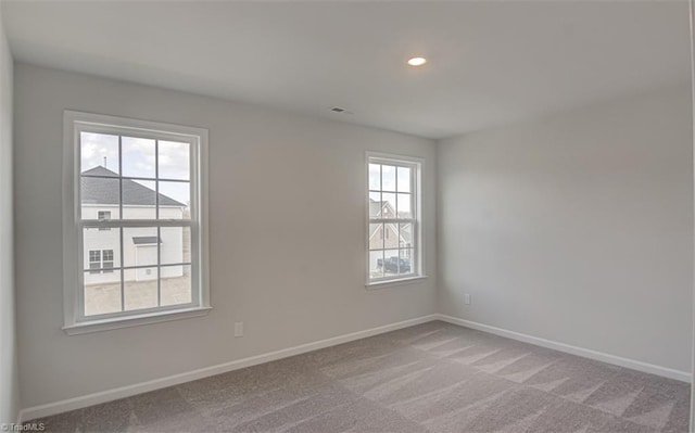 carpeted spare room with recessed lighting, visible vents, and baseboards