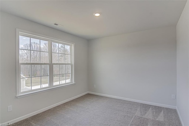 unfurnished room with carpet floors, baseboards, and visible vents