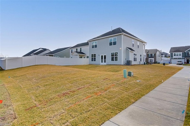 back of property with a yard, cooling unit, fence, and a residential view