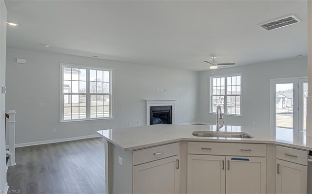 kitchen with open floor plan, light countertops, a sink, and visible vents