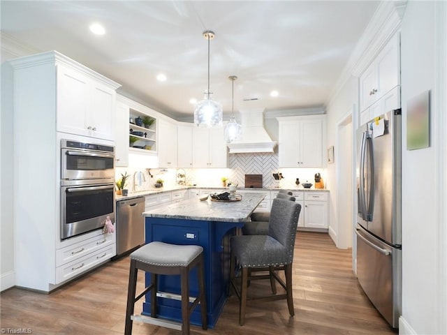 1659 Angus Ridge Dr, Kernersville, NC 27284 - kitchen with stainless steel appliances, custom exhaust hood, white cabinets, a kitchen breakfast bar, and a center island