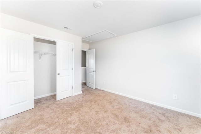 unfurnished bedroom featuring light colored carpet and a closet