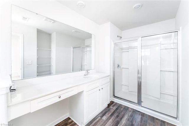 bathroom with wood-type flooring, vanity, and walk in shower