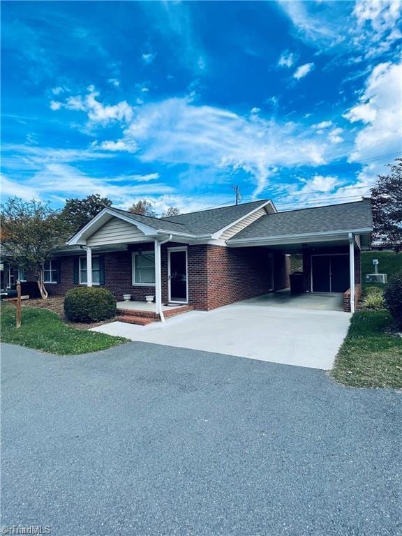 ranch-style home with a carport and covered porch