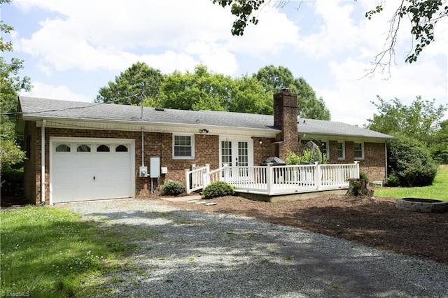 4345 Mcintyre Rd, Gibsonville, NC 27249 - view of front of property with an attached garage, gravel driveway, brick siding, a chimney, and a wooden deck