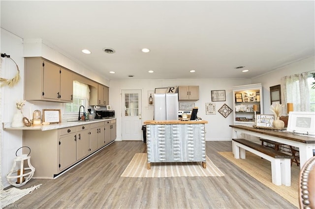 4345 Mcintyre Rd, Gibsonville, NC 27249 - kitchen featuring light countertops, light wood-style floors, crown molding, stainless steel microwave, and recessed lighting