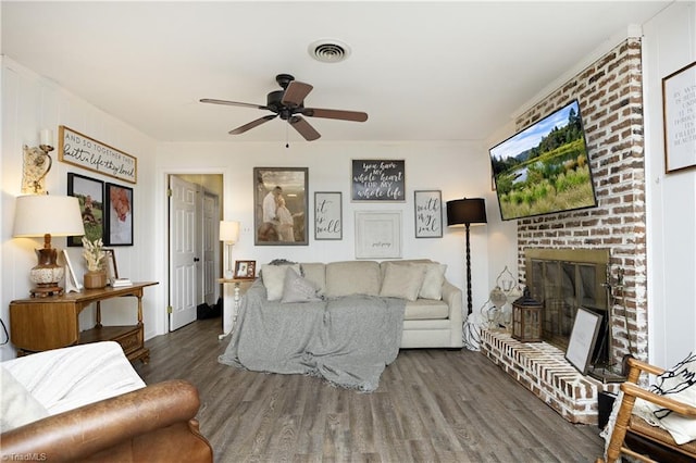 4345 Mcintyre Rd, Gibsonville, NC 27249 - living room featuring wood finished floors, a ceiling fan, and a brick fireplace