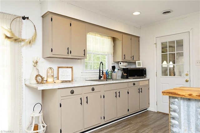 4345 Mcintyre Rd, Gibsonville, NC 27249 - kitchen with stainless steel microwave, light countertops, wood finished floors, and ornamental molding