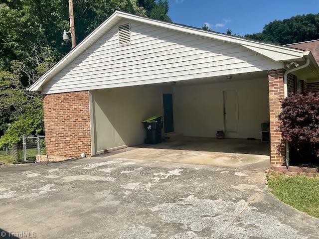 327 Lanier Dr, Lexington, NC 27295 - view of side of home with brick siding, concrete driveway, and a carport
