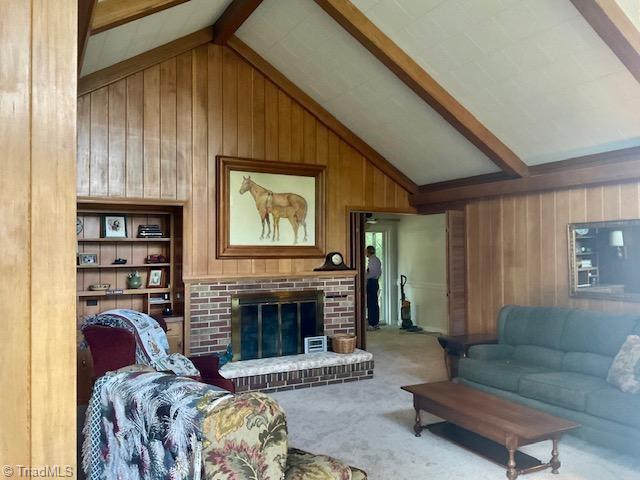327 Lanier Dr, Lexington, NC 27295 - living area featuring wood walls, carpet, and a brick fireplace