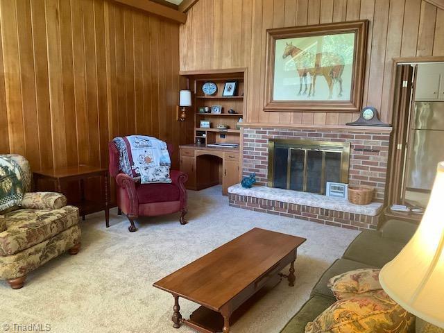 327 Lanier Dr, Lexington, NC 27295 - living room with wood walls, carpet flooring, and a fireplace