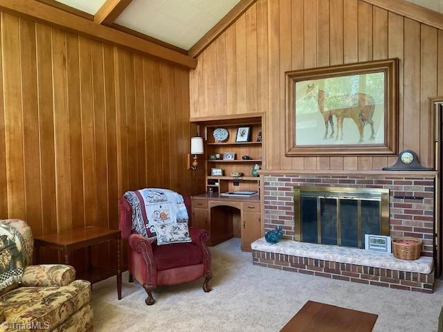 327 Lanier Dr, Lexington, NC 27295 - carpeted living area with wood walls, a fireplace, and vaulted ceiling