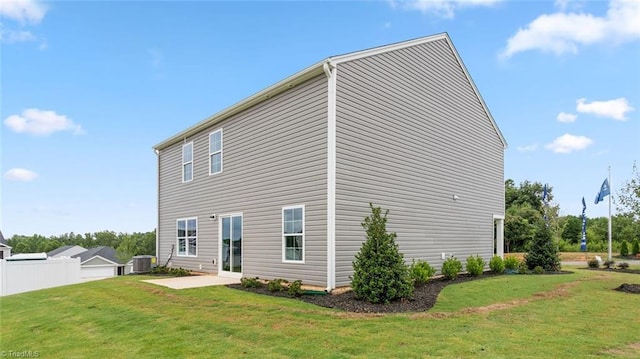 back of house featuring cooling unit, a yard, and a patio