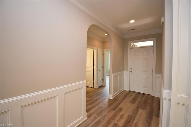 entrance foyer with ornamental molding and hardwood / wood-style flooring