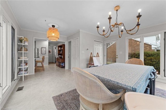 tiled dining area featuring crown molding and a chandelier