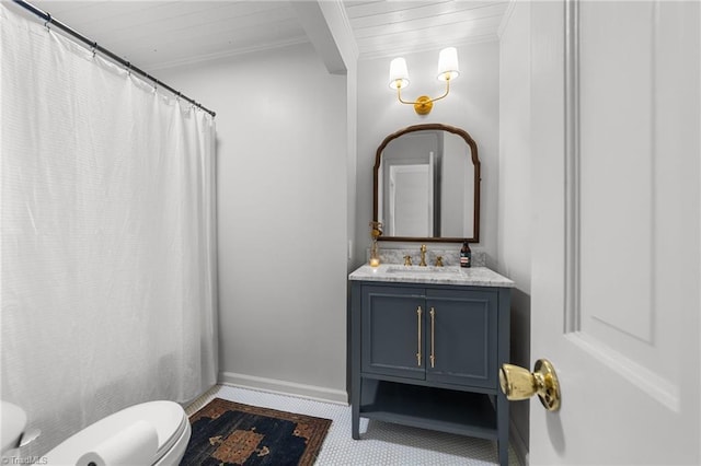 bathroom with vanity, beamed ceiling, ornamental molding, and toilet