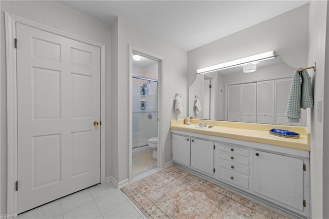 bathroom with tile patterned floors, toilet, an enclosed shower, and vanity