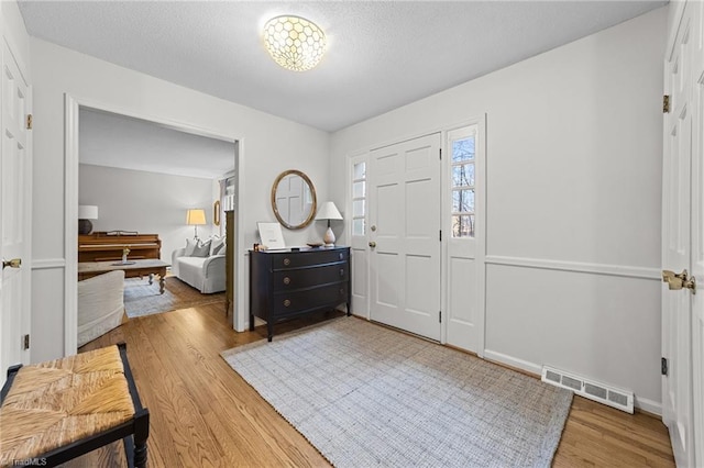 entrance foyer with hardwood / wood-style floors and a textured ceiling