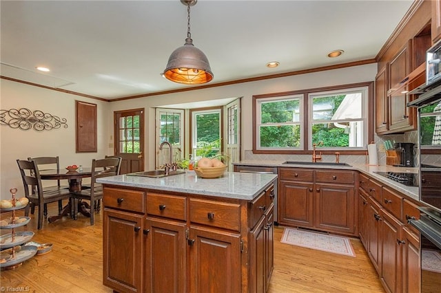 250 Oakmont Ter, Lexington, NC 27295 - kitchen featuring light wood-style flooring, pendant lighting, ornamental molding, an island with sink, and light stone counters