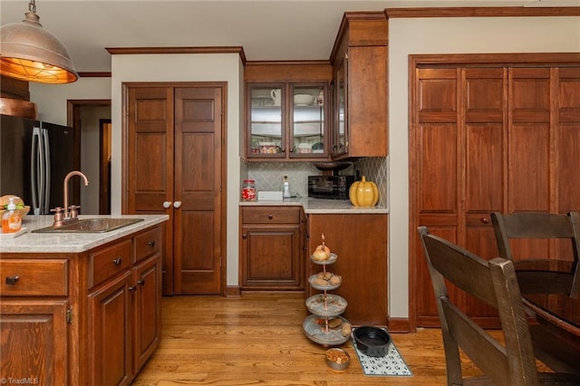 250 Oakmont Ter, Lexington, NC 27295 - kitchen with freestanding refrigerator, light wood-type flooring, light countertops, backsplash, and glass insert cabinets