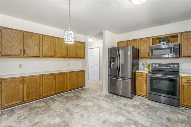 kitchen featuring a textured ceiling, appliances with stainless steel finishes, and decorative light fixtures