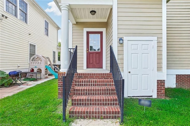 property entrance with a lawn