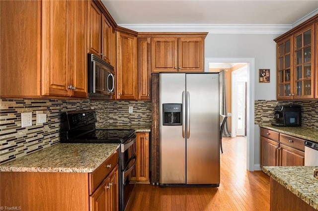 15 Orchard Grass Ct, Greensboro, NC 27410 - kitchen featuring appliances with stainless steel finishes, light wood-type flooring, decorative backsplash, light stone counters, and ornamental molding