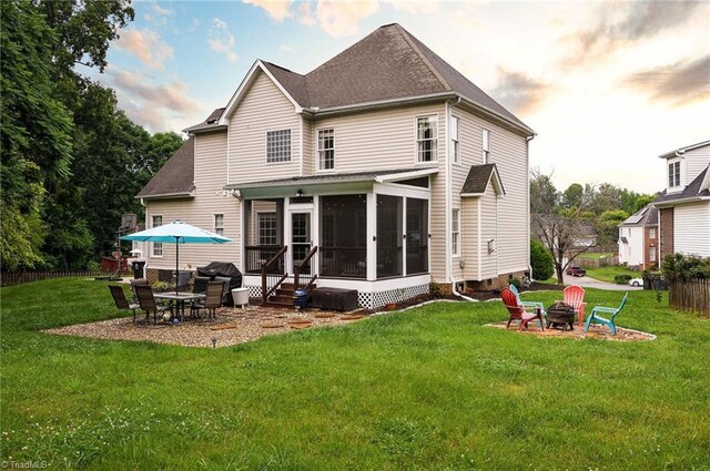 15 Orchard Grass Ct, Greensboro, NC 27410 - back of house featuring an outdoor fire pit, a sunroom, a lawn, a patio area, and roof with shingles