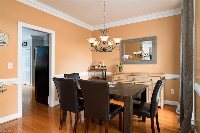 15 Orchard Grass Ct, Greensboro, NC 27410 - dining area with a chandelier, crown molding, wood-type flooring, and baseboards