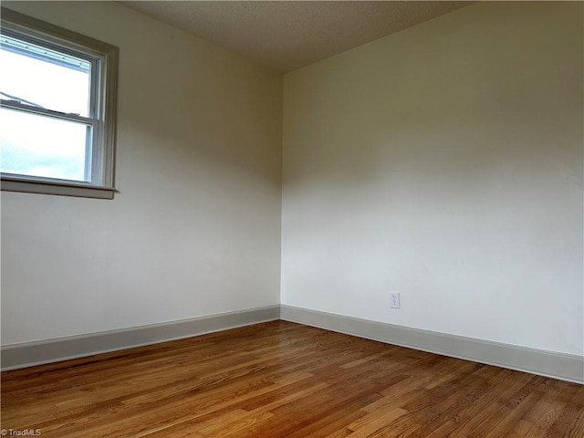 spare room featuring hardwood / wood-style flooring and a textured ceiling