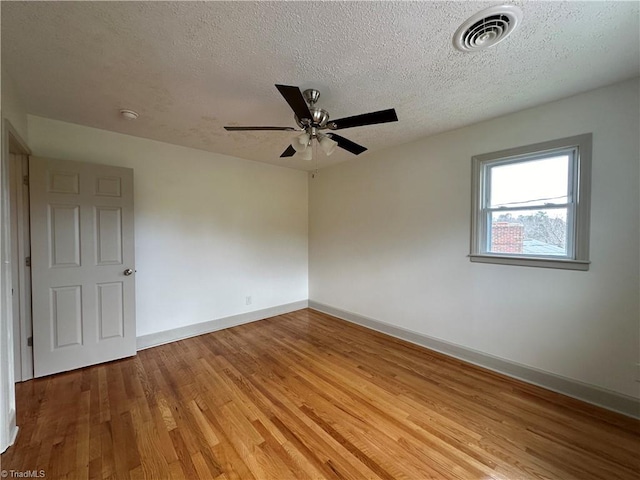 empty room featuring hardwood / wood-style flooring, ceiling fan, and a textured ceiling